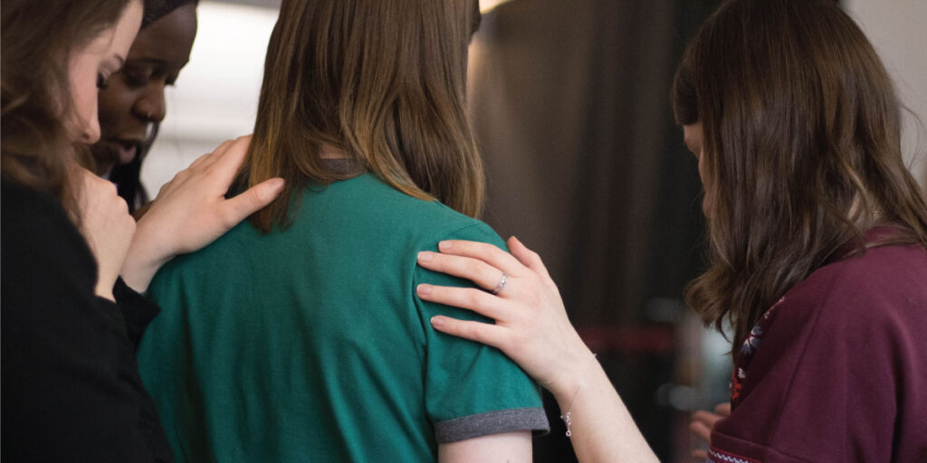 Circle Up Experience blog post: Corporate Grief: When the Workplace Breaks Your Heart. (Picture of group of work colleagues consoling each other).